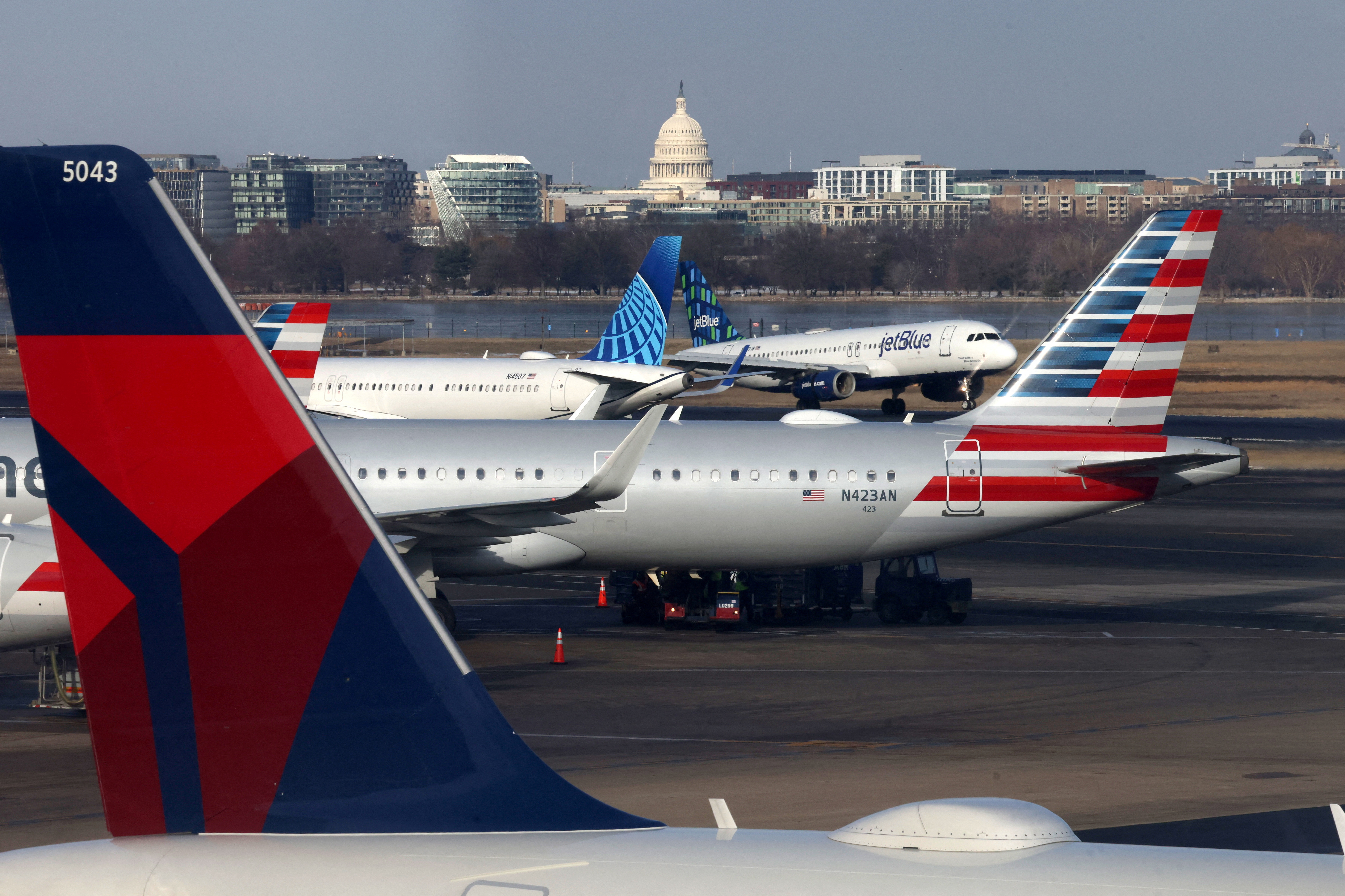 FILE PHOTO: A JetBlue aircraft lands under the DC skyline featuring the U.S. Capitol building