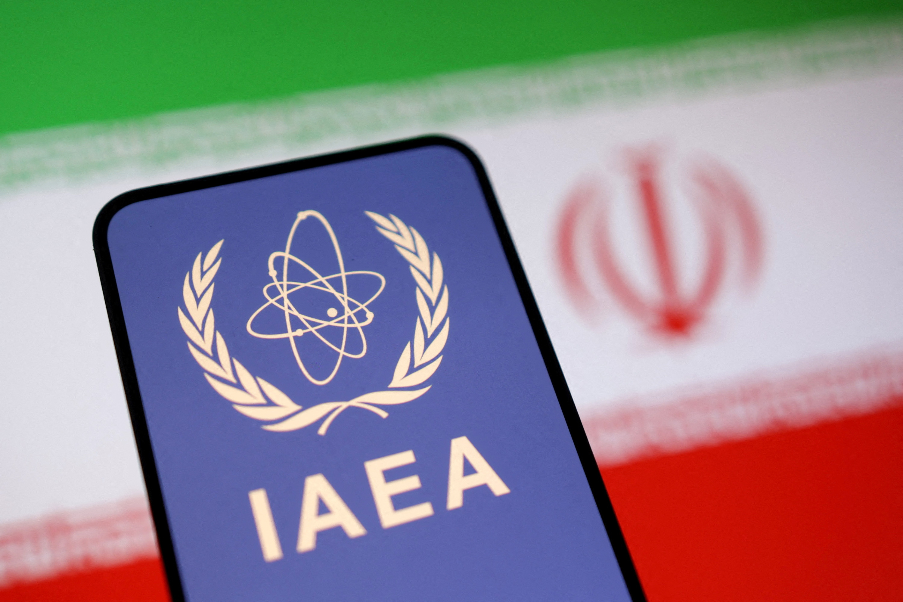 FILE PHOTO: Illustration shows International Atomic Energy Agency (IAEA) logo and Iranian flag