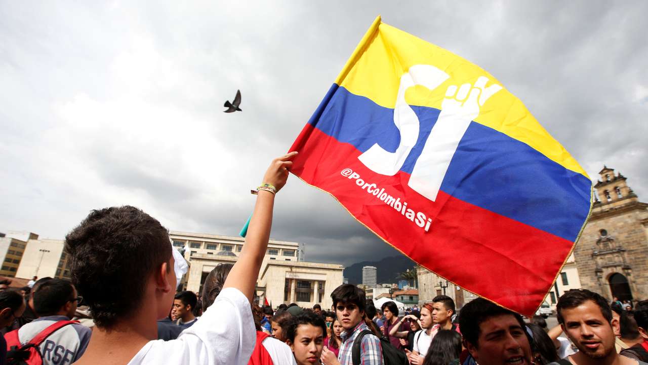 University students and supporters of the peace deal signed between the government and Revolutionary Armed Forces of Colombia (FARC) rebels display a flag during a rally in front of Congress in Bogota