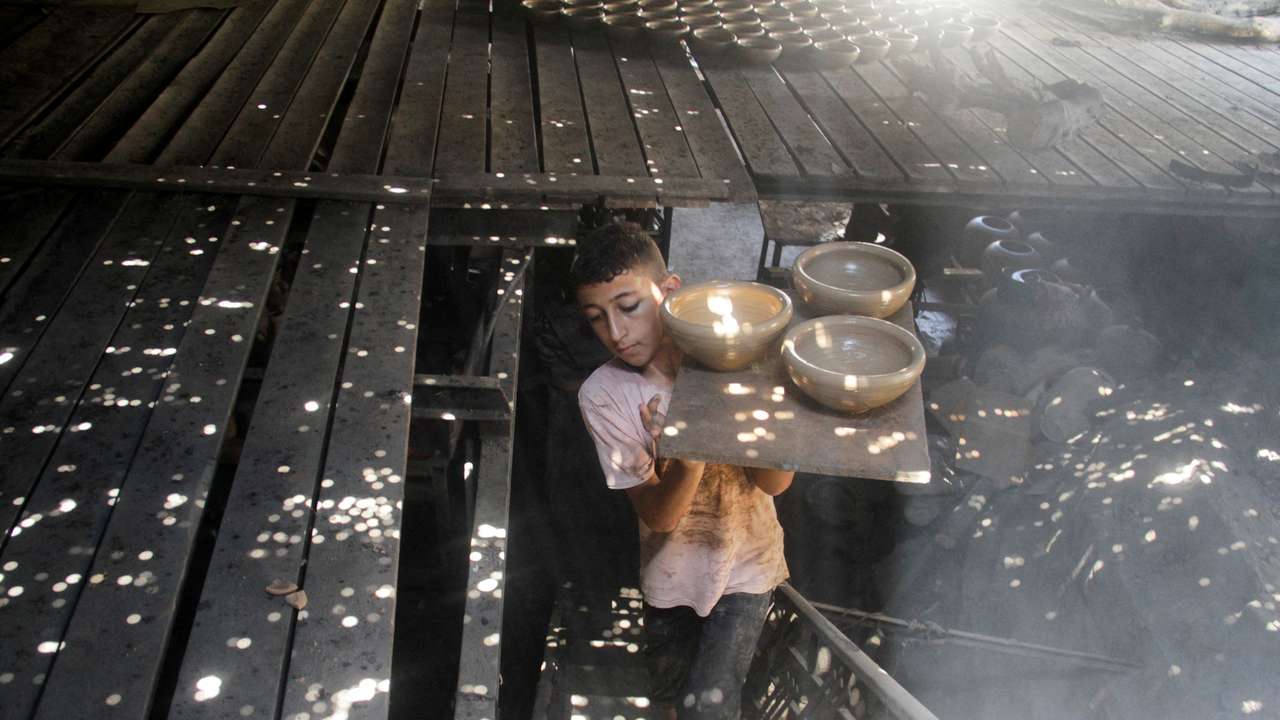 Palestinians work in a pottery workshop, in Gaza City