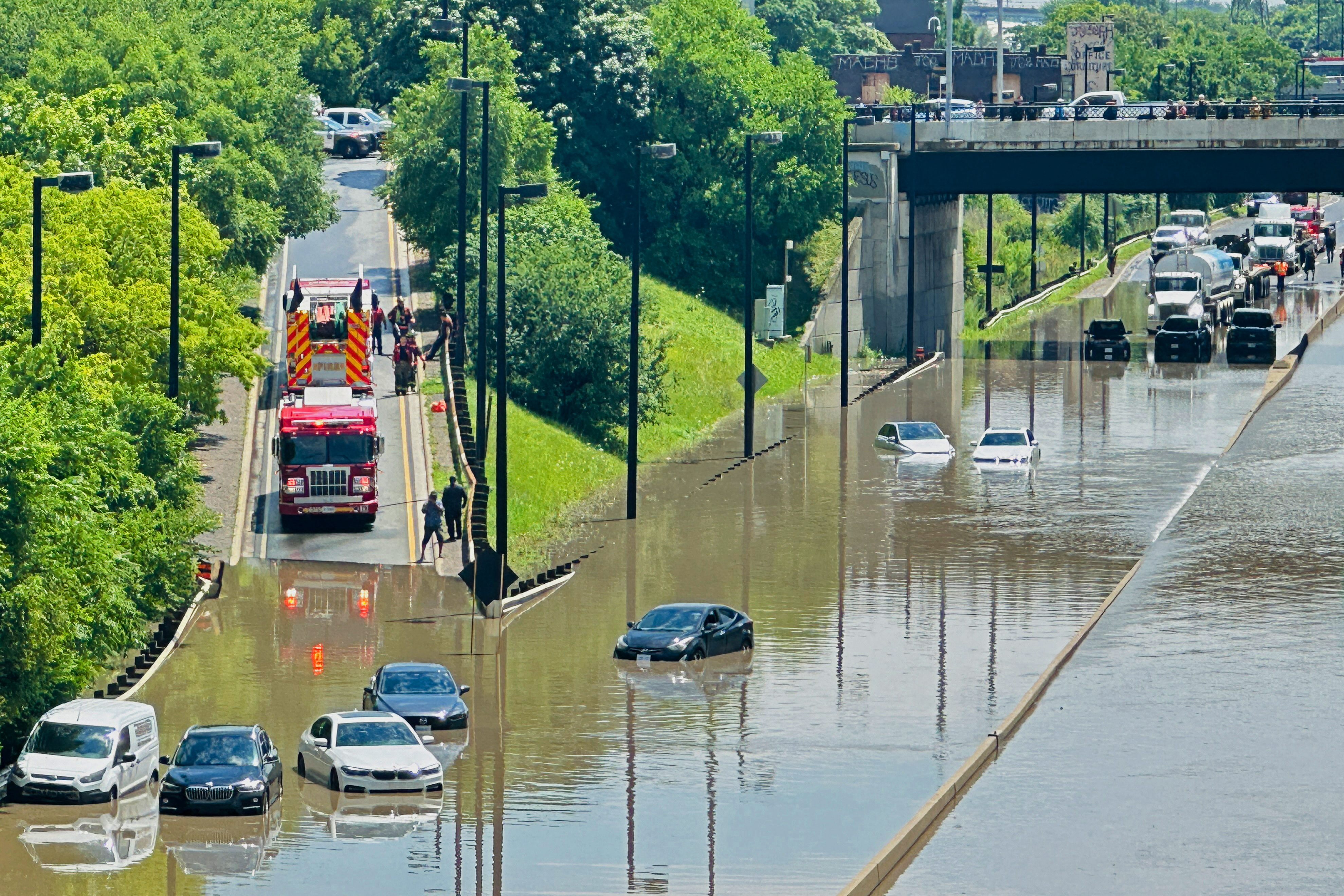A cyclist views a flooded section of the Don Valley Parkway after heavy rains hit Toronto