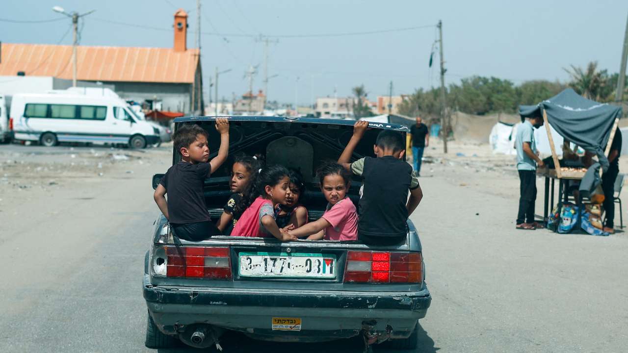 Children sit in a car trunk, in Rafah