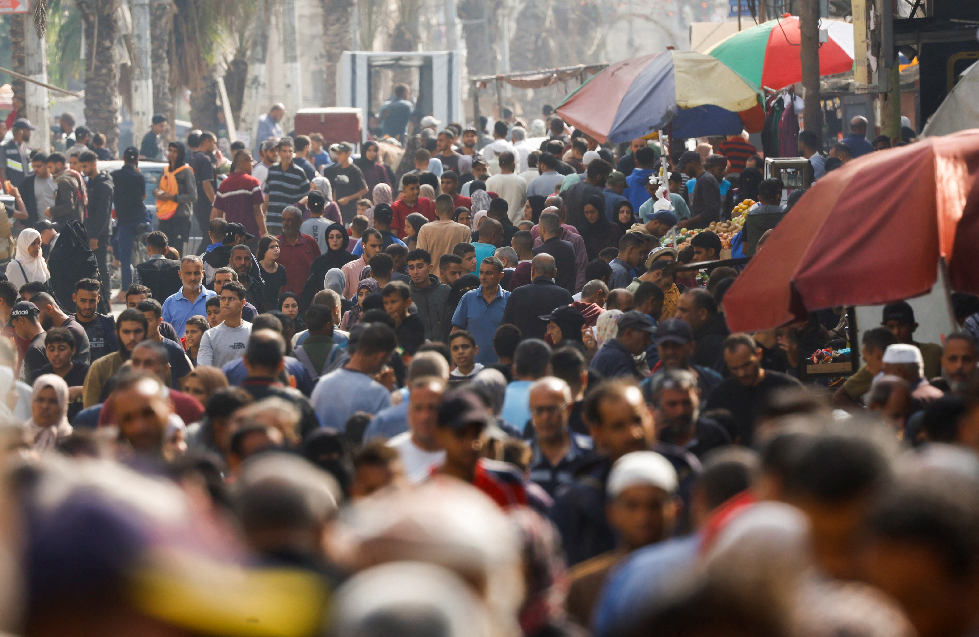 People gather and shop at a local market, in Nuseirat