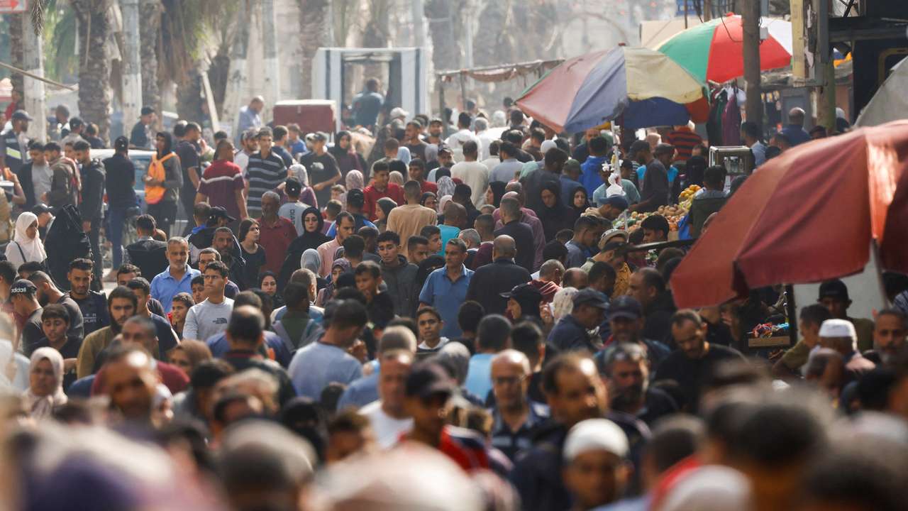 People gather and shop at a local market, in Nuseirat