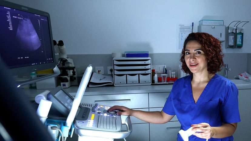 Syrian gynaecologist Sandy Issa, 36, poses for a photo with an ultrasonic unit in a clinic in Berlin