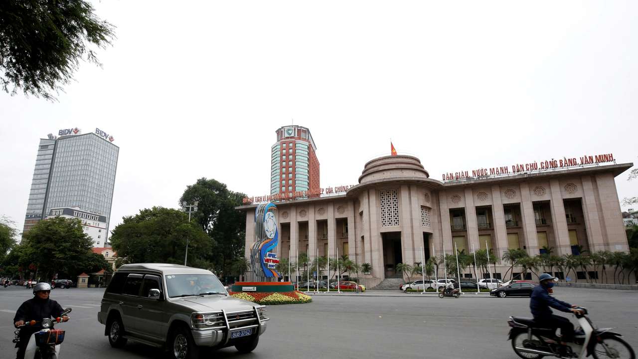 FILE PHOTO: People go past the State Bank building in central Hanoi