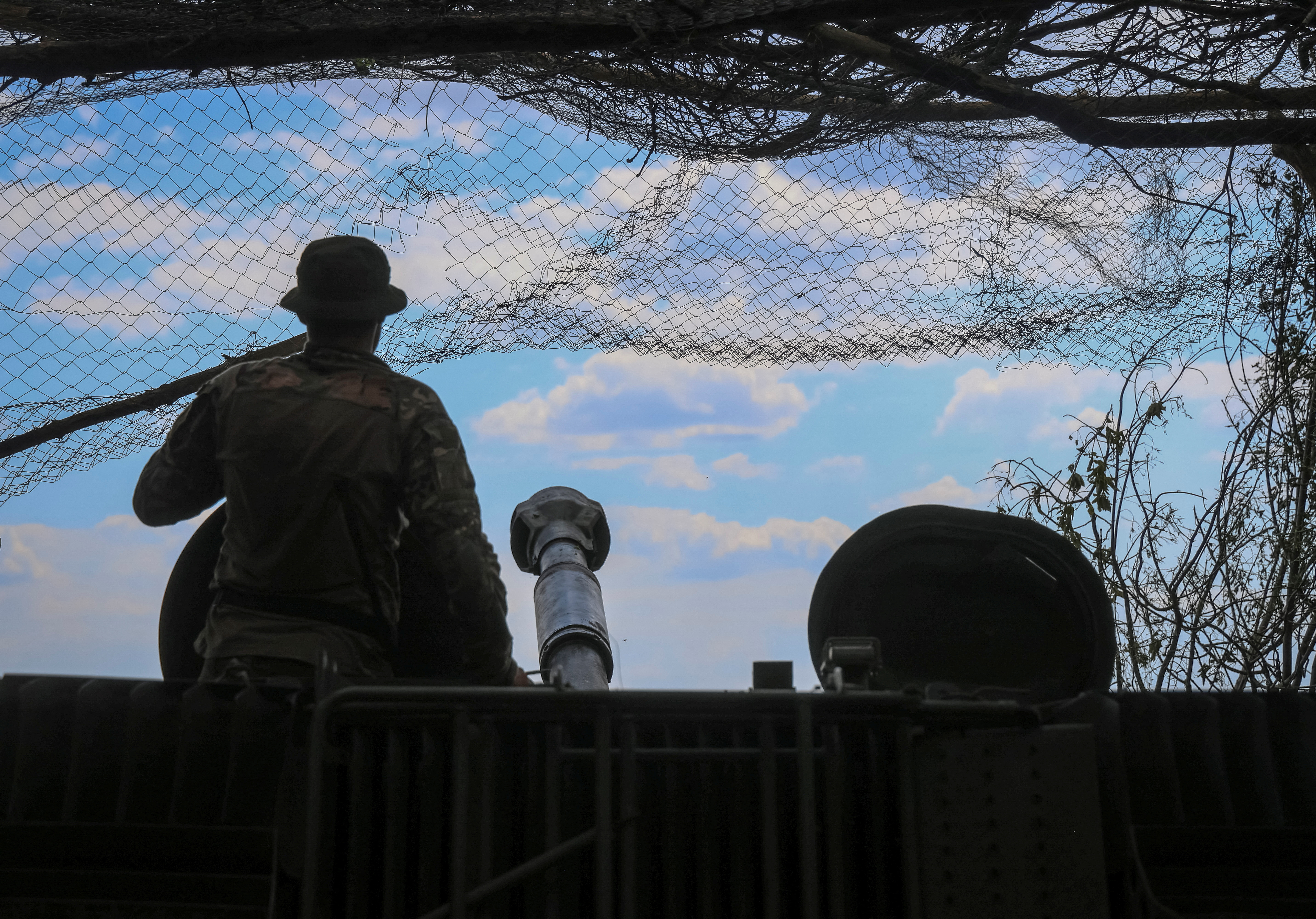 A Ukrainian serviceman prepares to fire a 2S1 Gvozdika self-propelled howitzer towards Russian troops in the Donetsk region