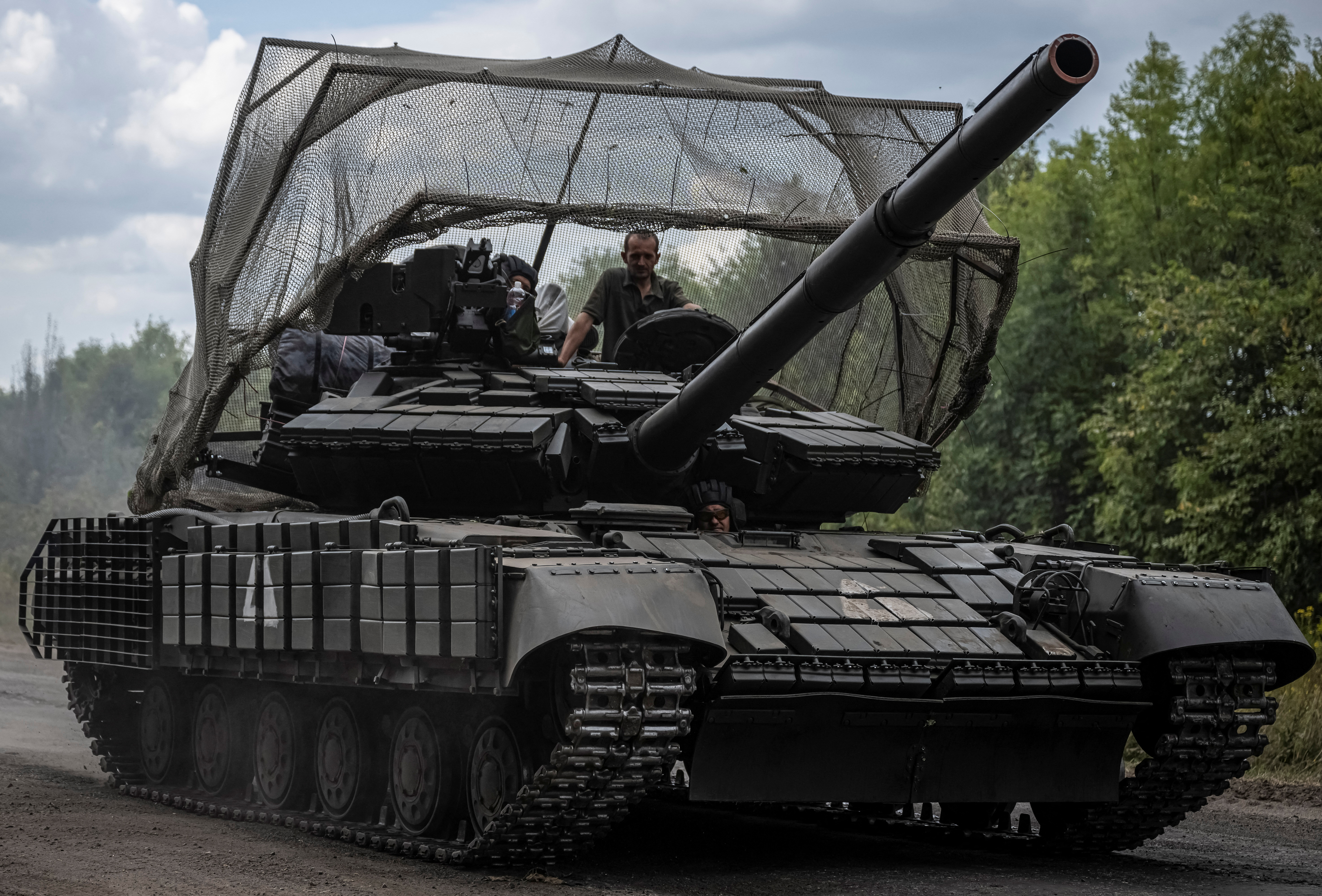 Ukrainian servicemen ride a tank near the Russian border in Sumy region