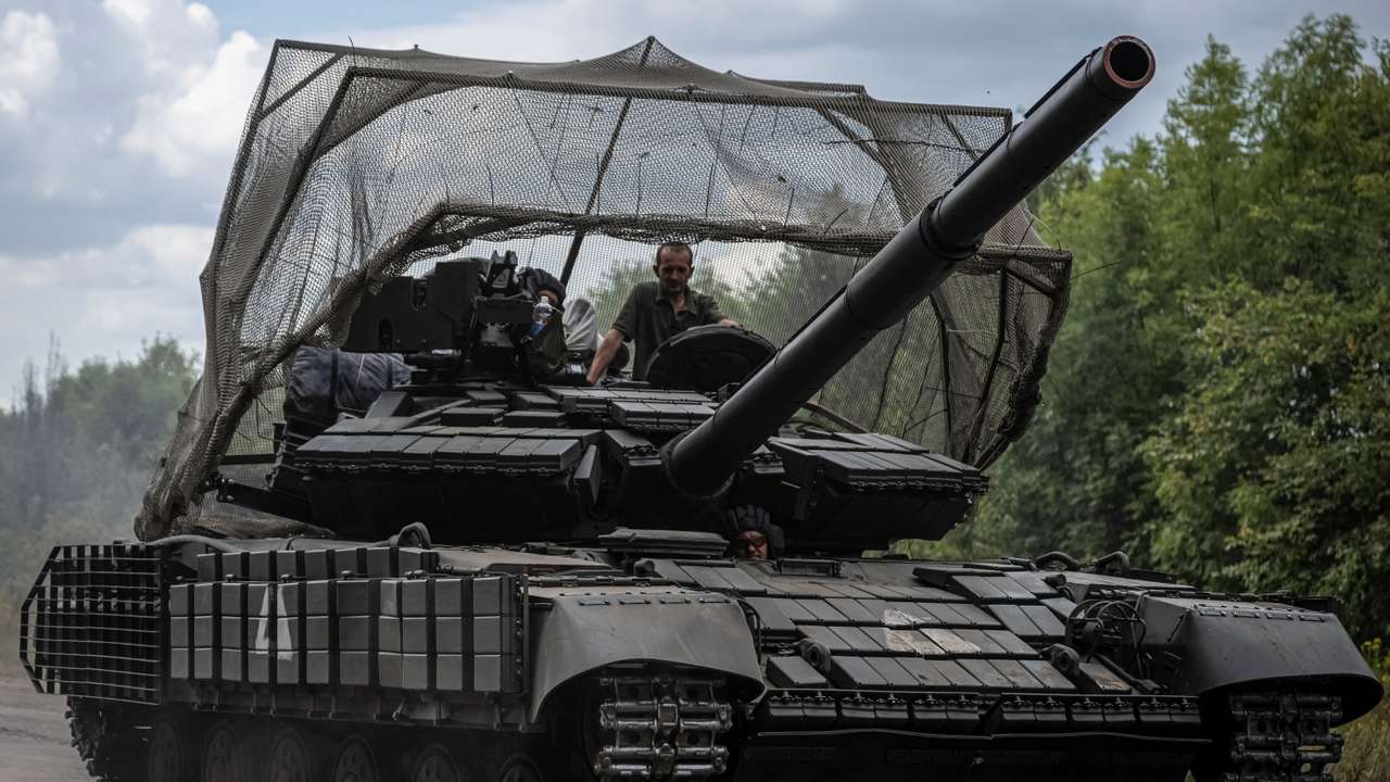 Ukrainian servicemen ride a tank near the Russian border in Sumy region