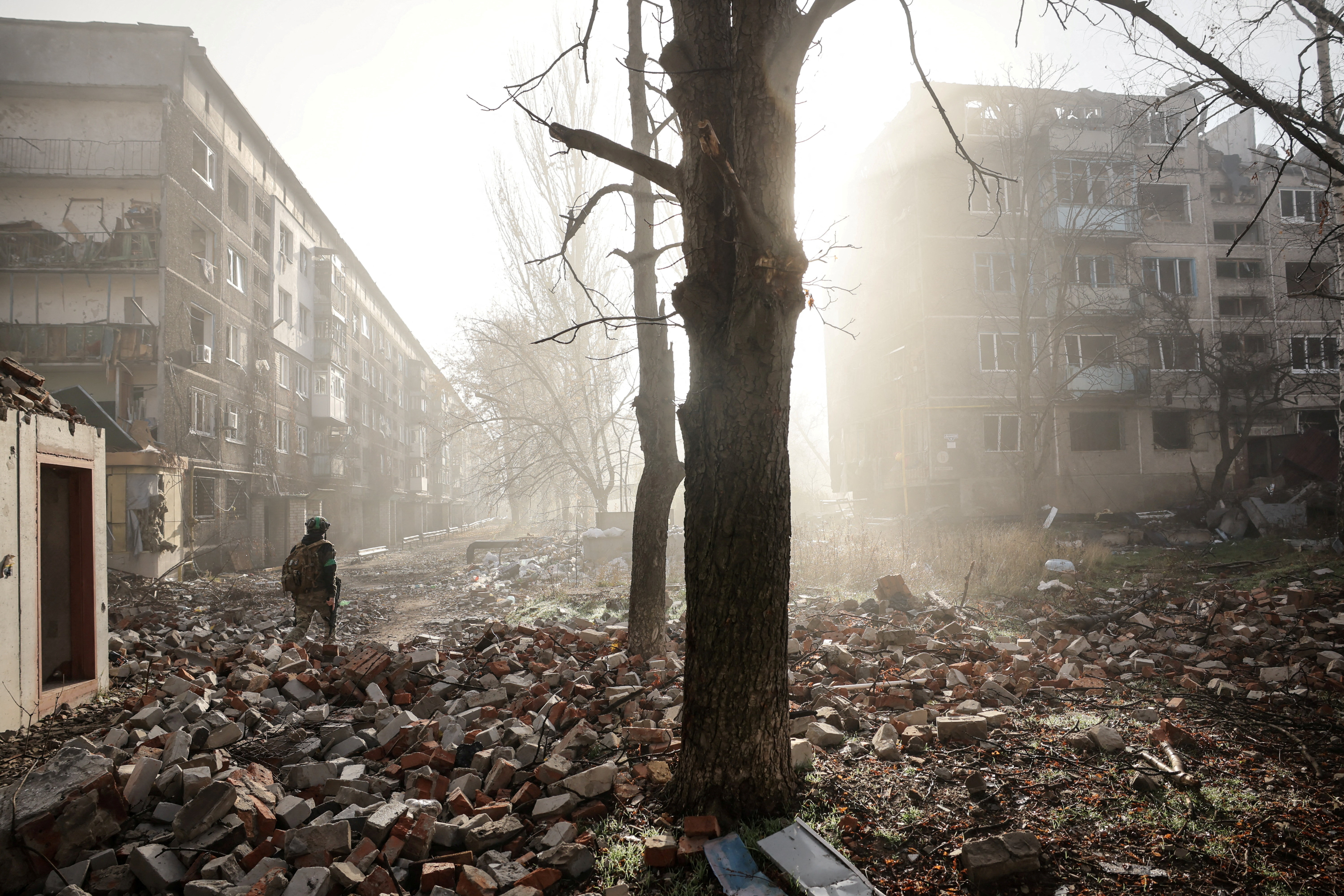 FILE PHOTO: Ukrainian serviceman walks near apartment buildings damaged by a Russian military strike in the frontline town of Kostiantynivka