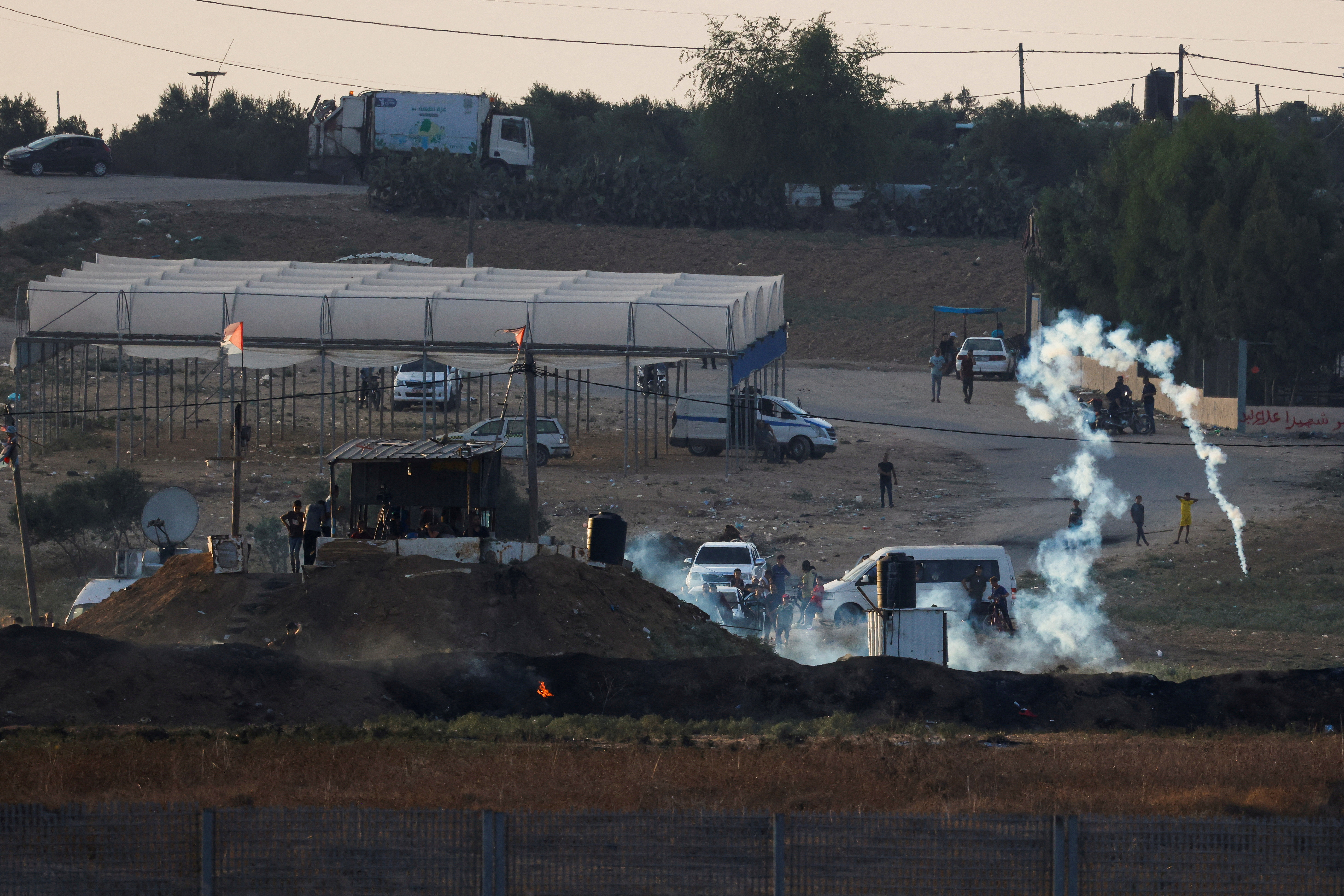 FILE PHOTO: Israeli soldiers and Palestinian protesters clash near the border between Israel and the Gaza Strip as seen from the Israeli side