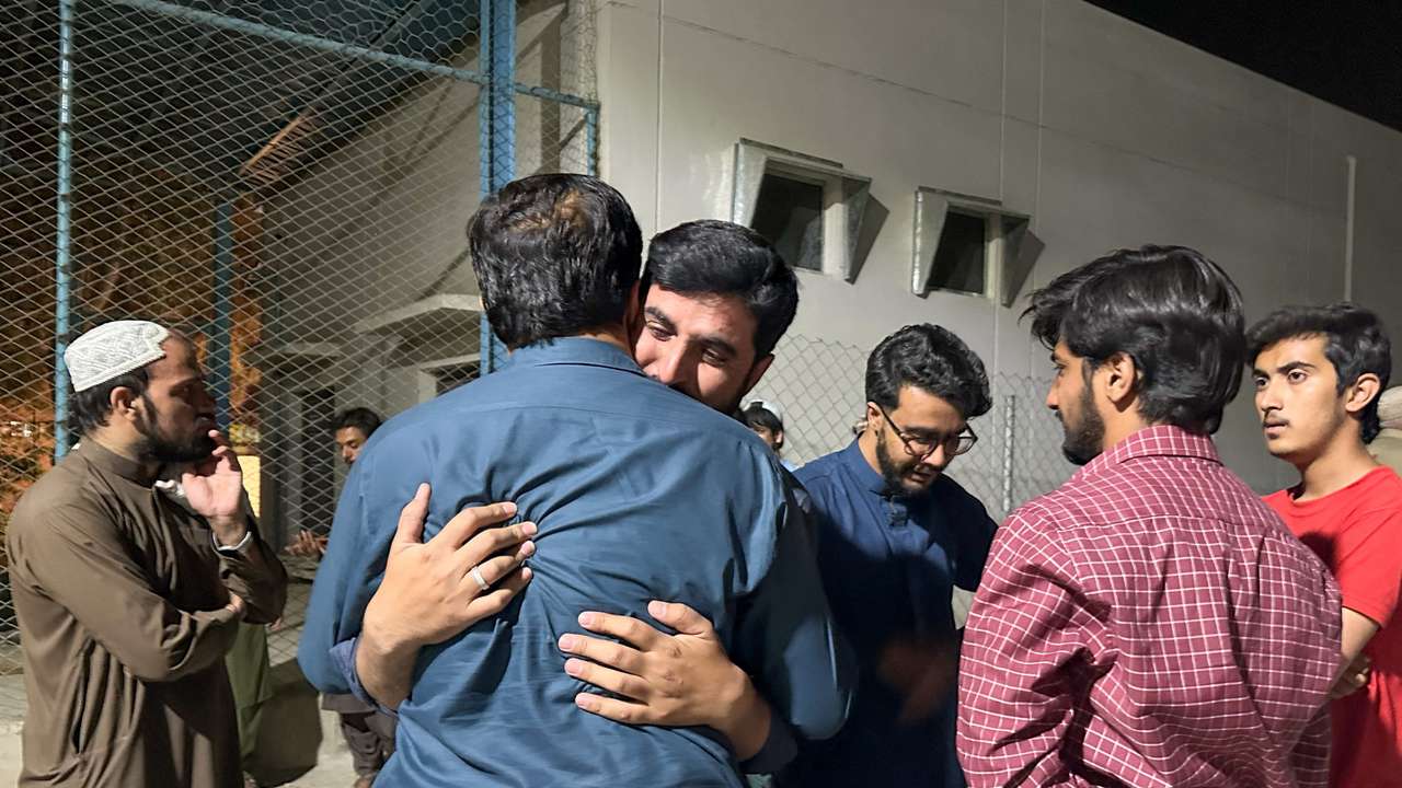 Men mourn the death of a relative, who was killed in a bomb blast at the public rally in Quetta, at hospital premises in Quetta