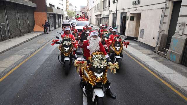 Police officers from the traffic squad wearing Christmas costumes ride on motorcycles through the streets of Lima, ahead of Christmas
