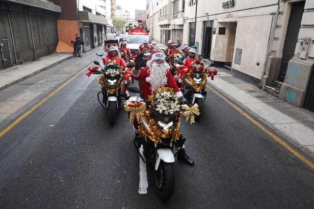 Police officers from the traffic squad wearing Christmas costumes ride on motorcycles through the streets of Lima, ahead of Christmas