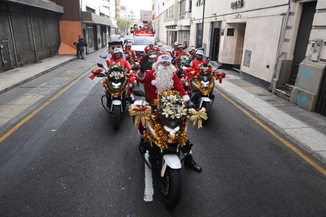 Police officers from the traffic squad wearing Christmas costumes ride on motorcycles through the streets of Lima, ahead of Christmas