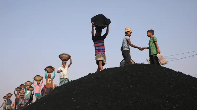 Coal workers are seen at a market as they unload a ferry in Dhaka
