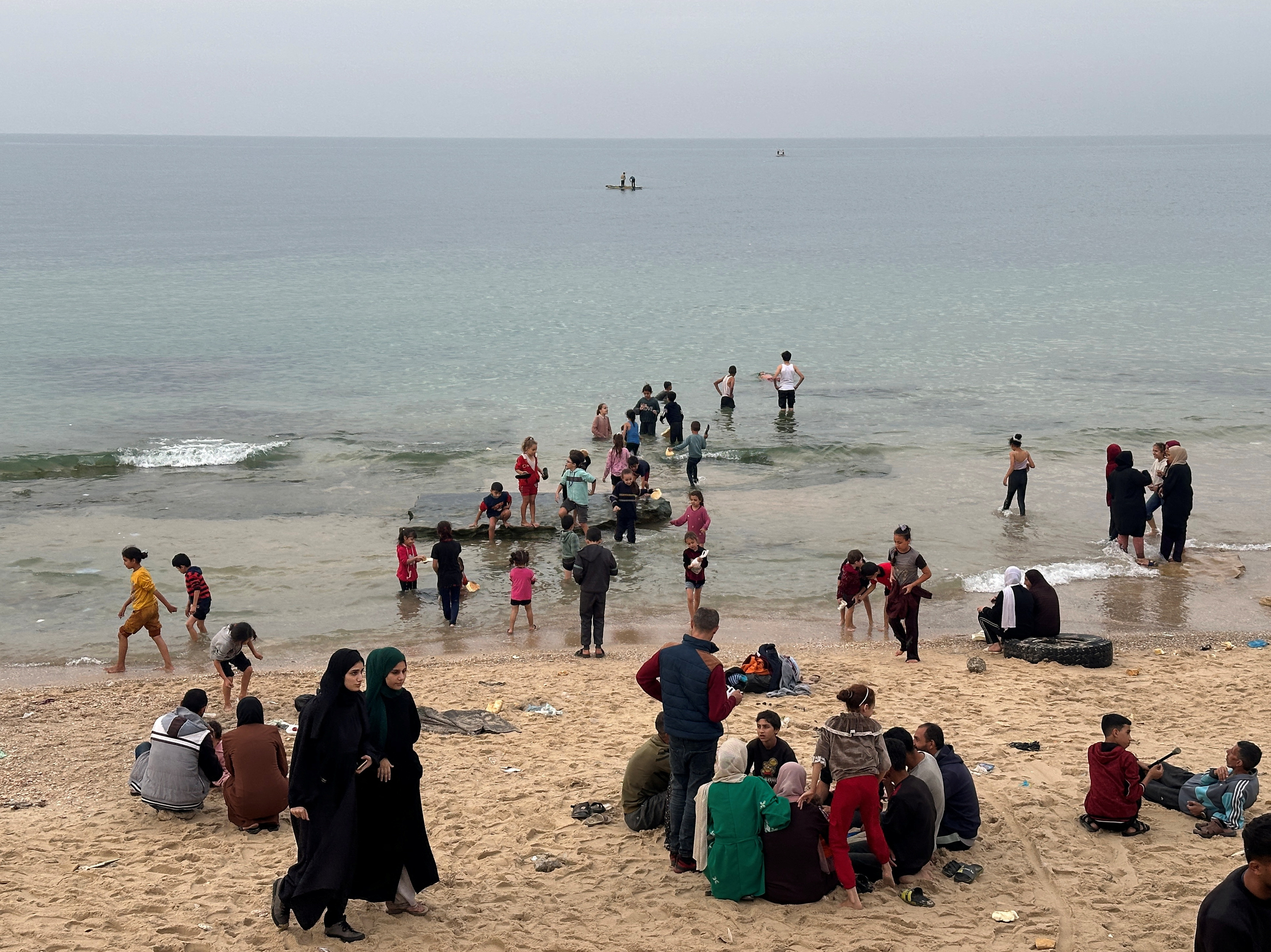 Palestinians spend time on a beach during the temporary truce in Deir al-Balah in the central Gaza Strip