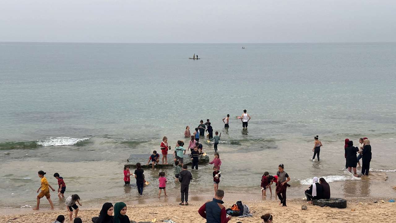 Palestinians spend time on a beach during the temporary truce in Deir al-Balah in the central Gaza Strip