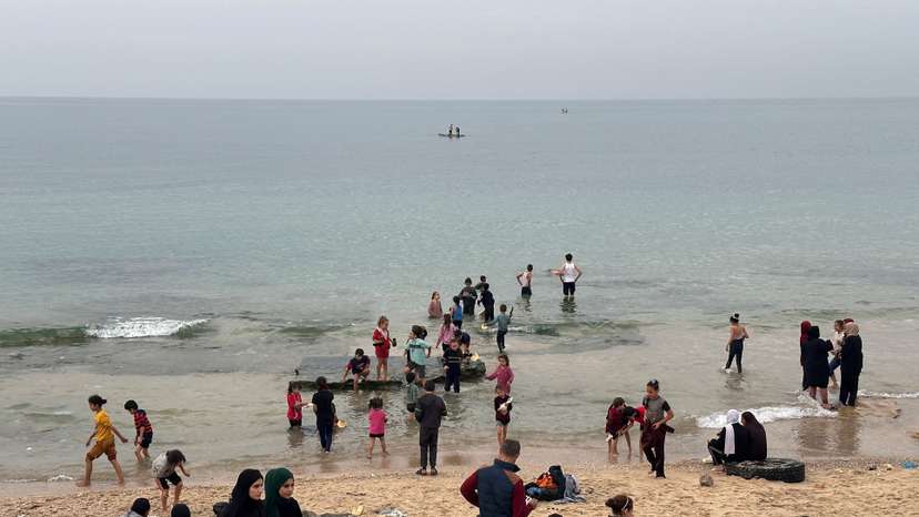 Palestinians spend time on a beach during the temporary truce in Deir al-Balah in the central Gaza Strip
