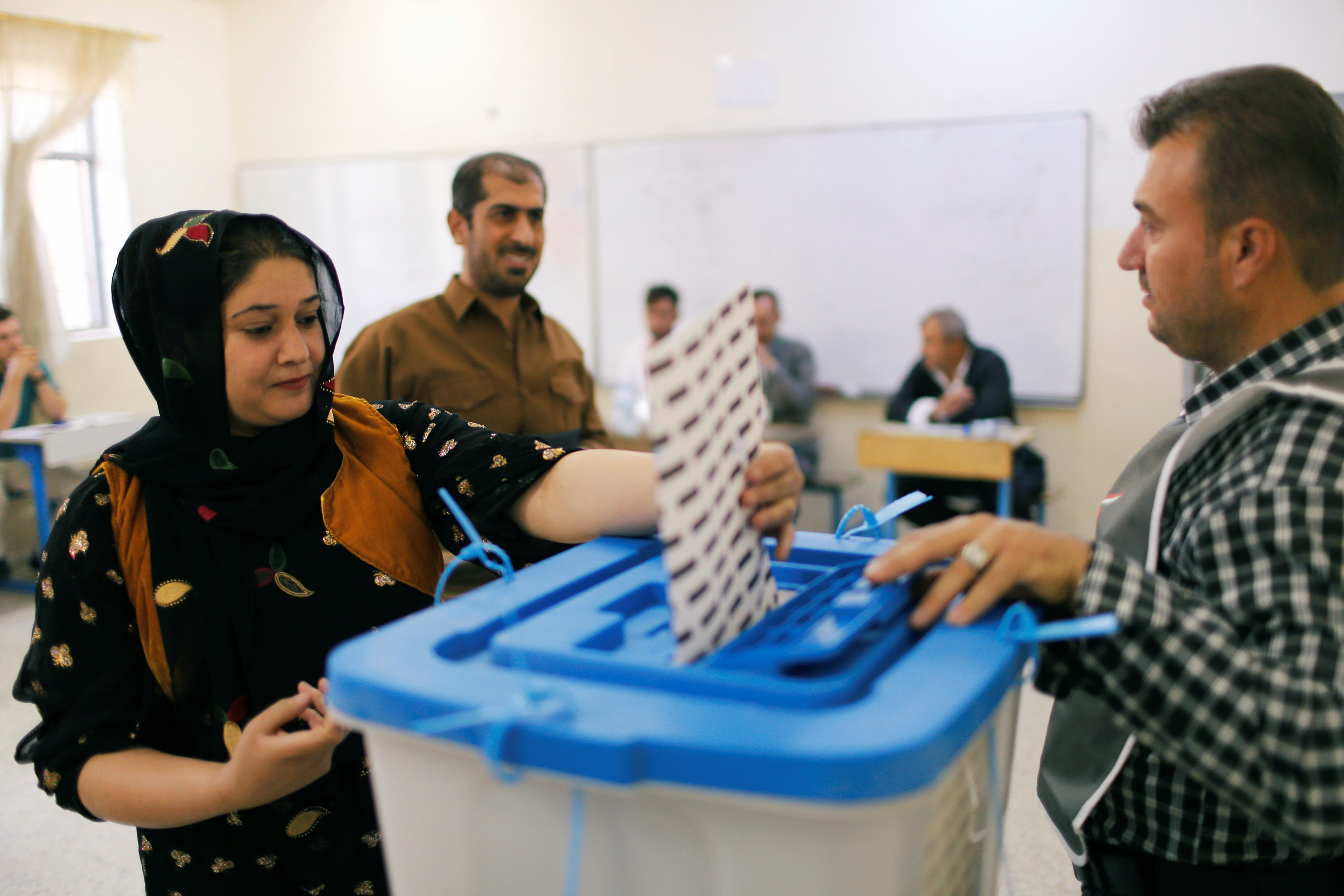 A Kurdish woman casts her vote at a polling station, during parliamentary elections in the semi-autonomous region in Erbil
