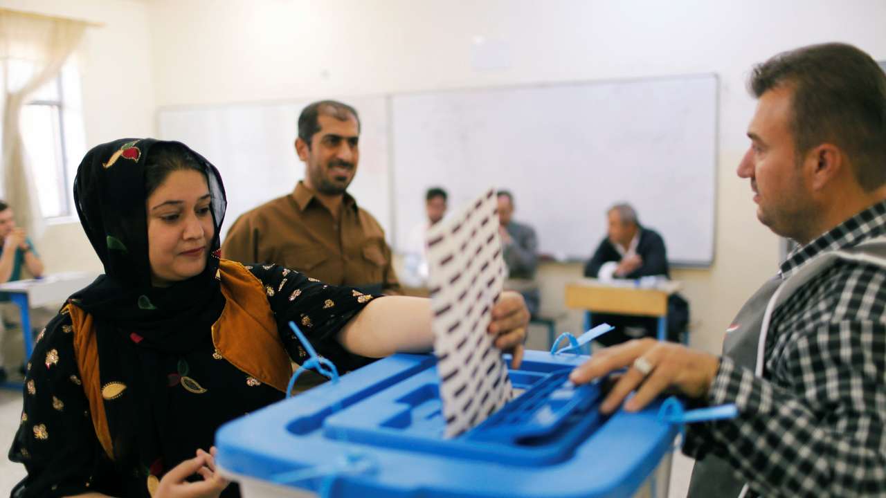 A Kurdish woman casts her vote at a polling station, during parliamentary elections in the semi-autonomous region in Erbil