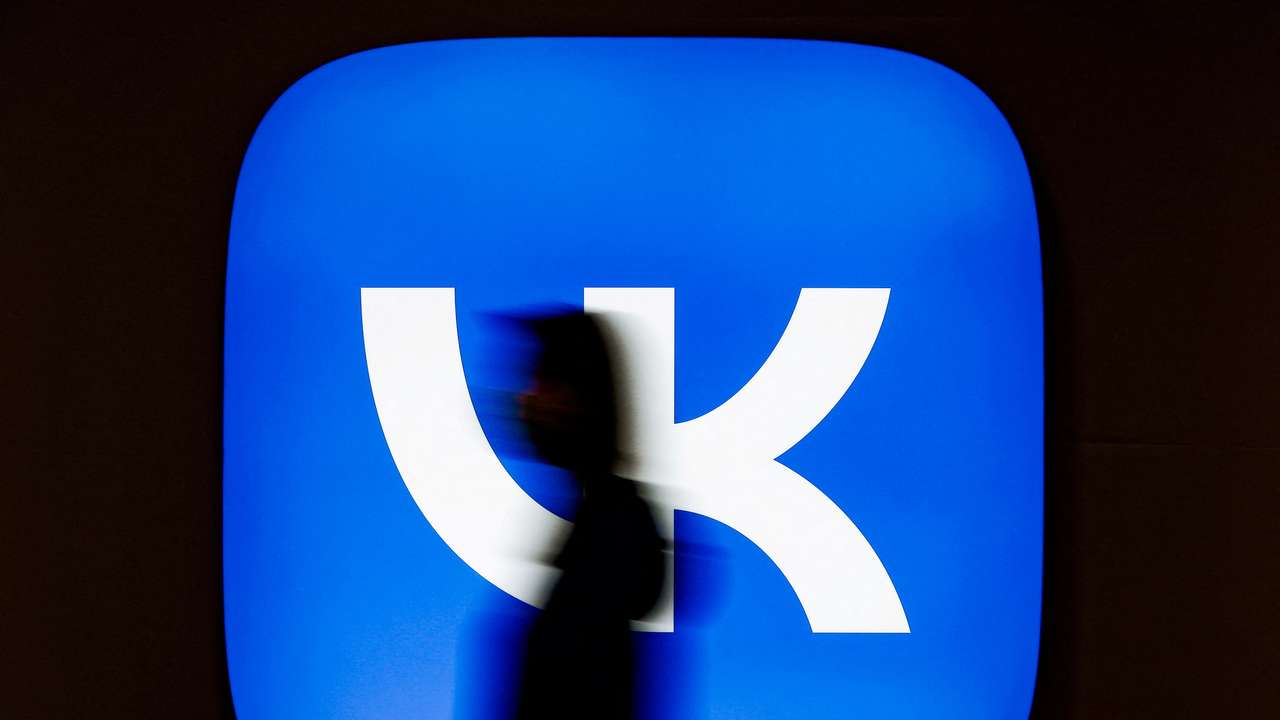 FILE PHOTO: An employee of Russian internet company VK walks past the company's logo at its headquarters in Moscow