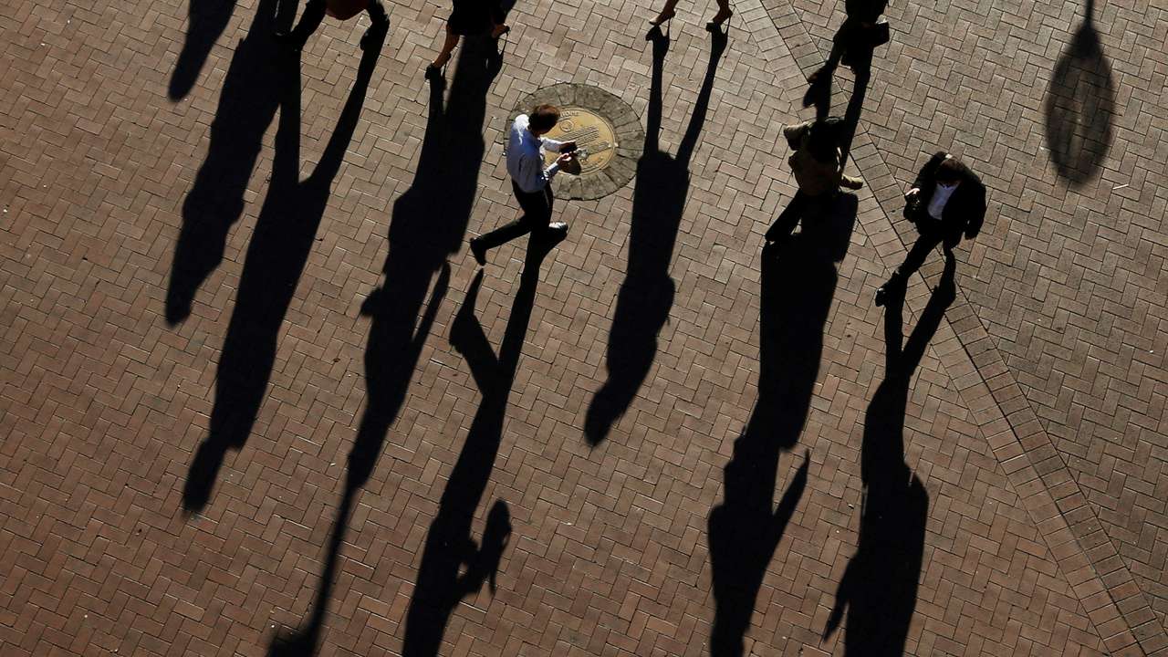 FILE PHOTO: Commuters cast their shadows as they arrive to the Central Business District at the morning rush hour in Sydney