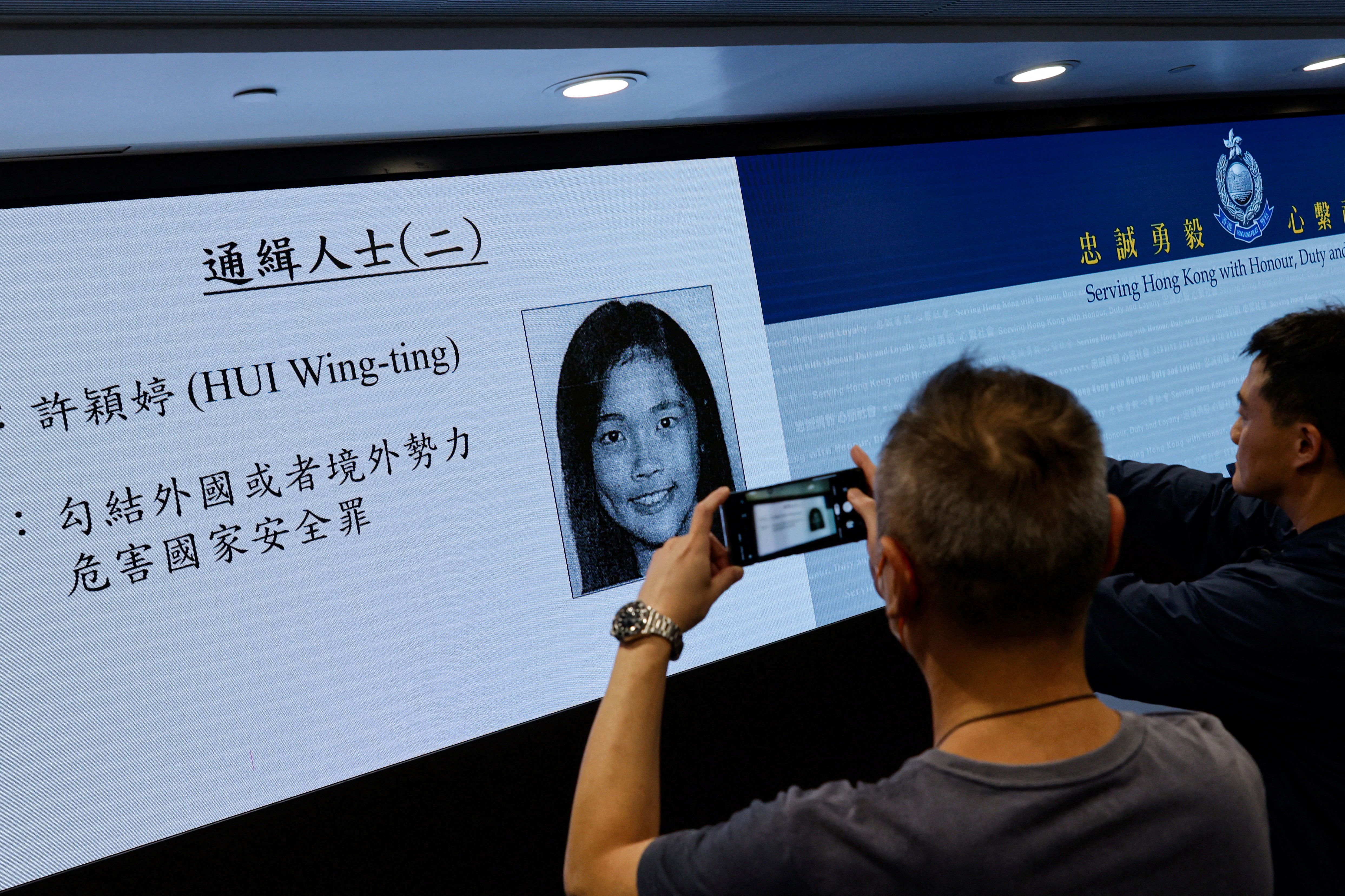 Image of activist Frances Hui is displayed during a press conference to issue arrest warrants in Hong Kong