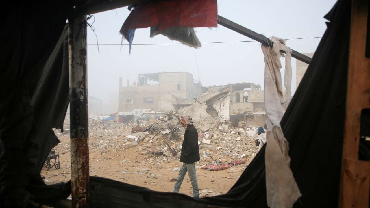 Palestinians inspect the damage to a tent for displaced people, after an Israeli airstrike, in Khan Younis