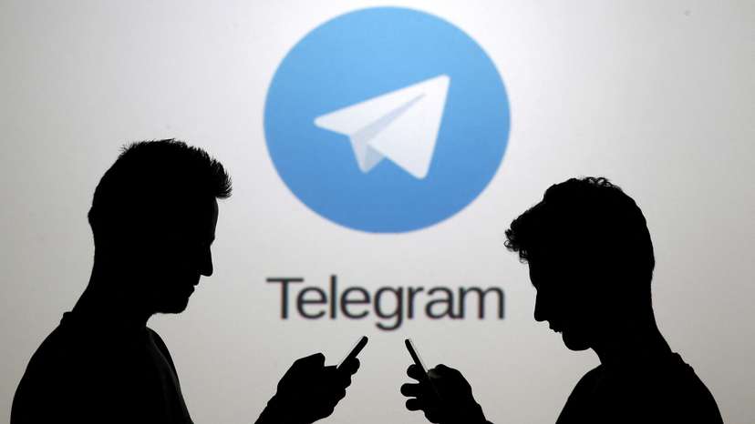 FILE PHOTO: Two men pose with smartphones in front of a screen showing the Telegram logo in this picture illustration taken in Zenica