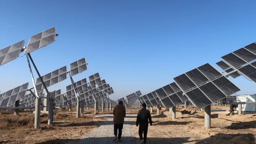 Workers walk at a solar power station in Tongchuan, Shaanxi