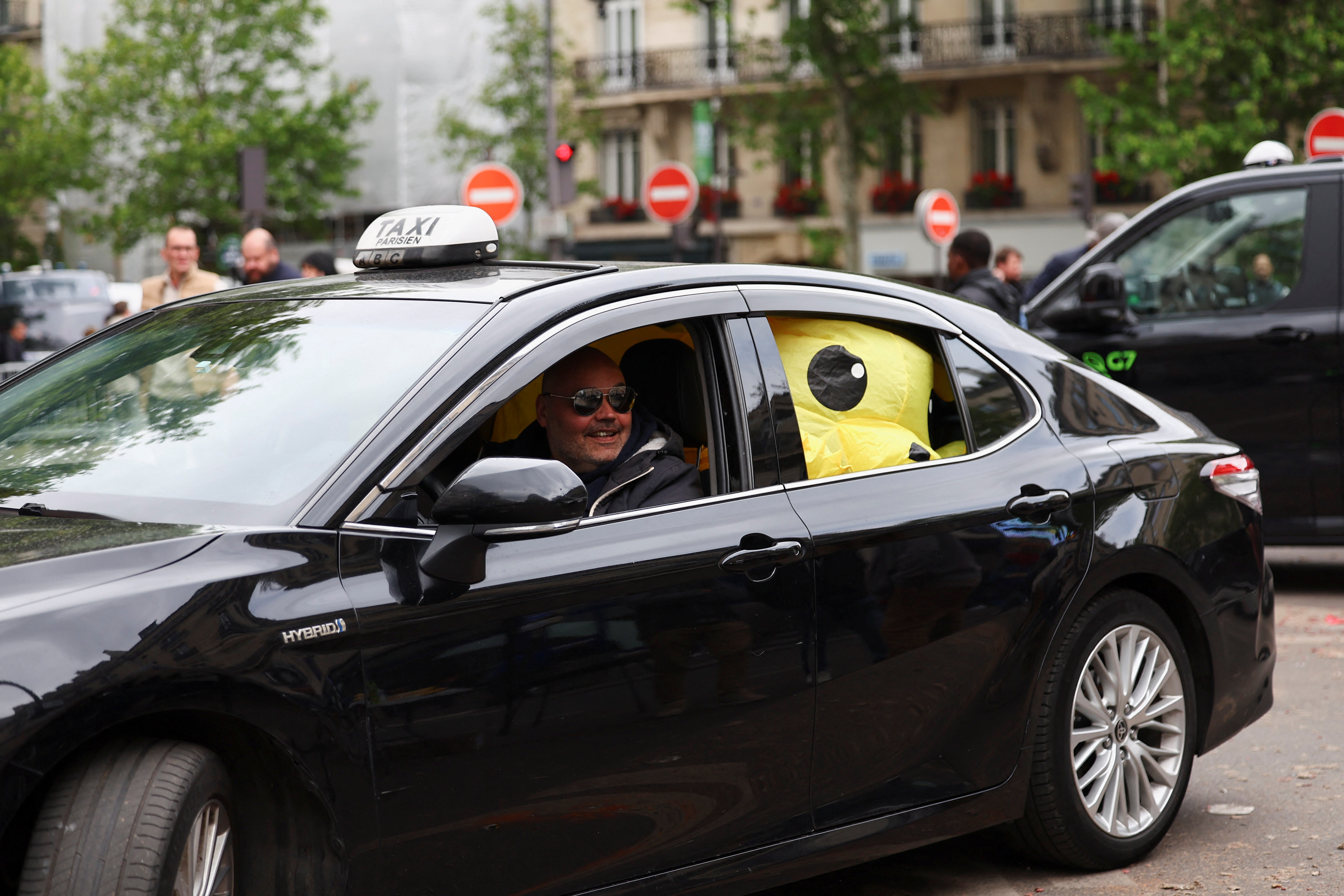 French taxi drivers gather for a strike protesting over proposed government cuts to cash for ferrying patients to and from medical appointments, in Paris