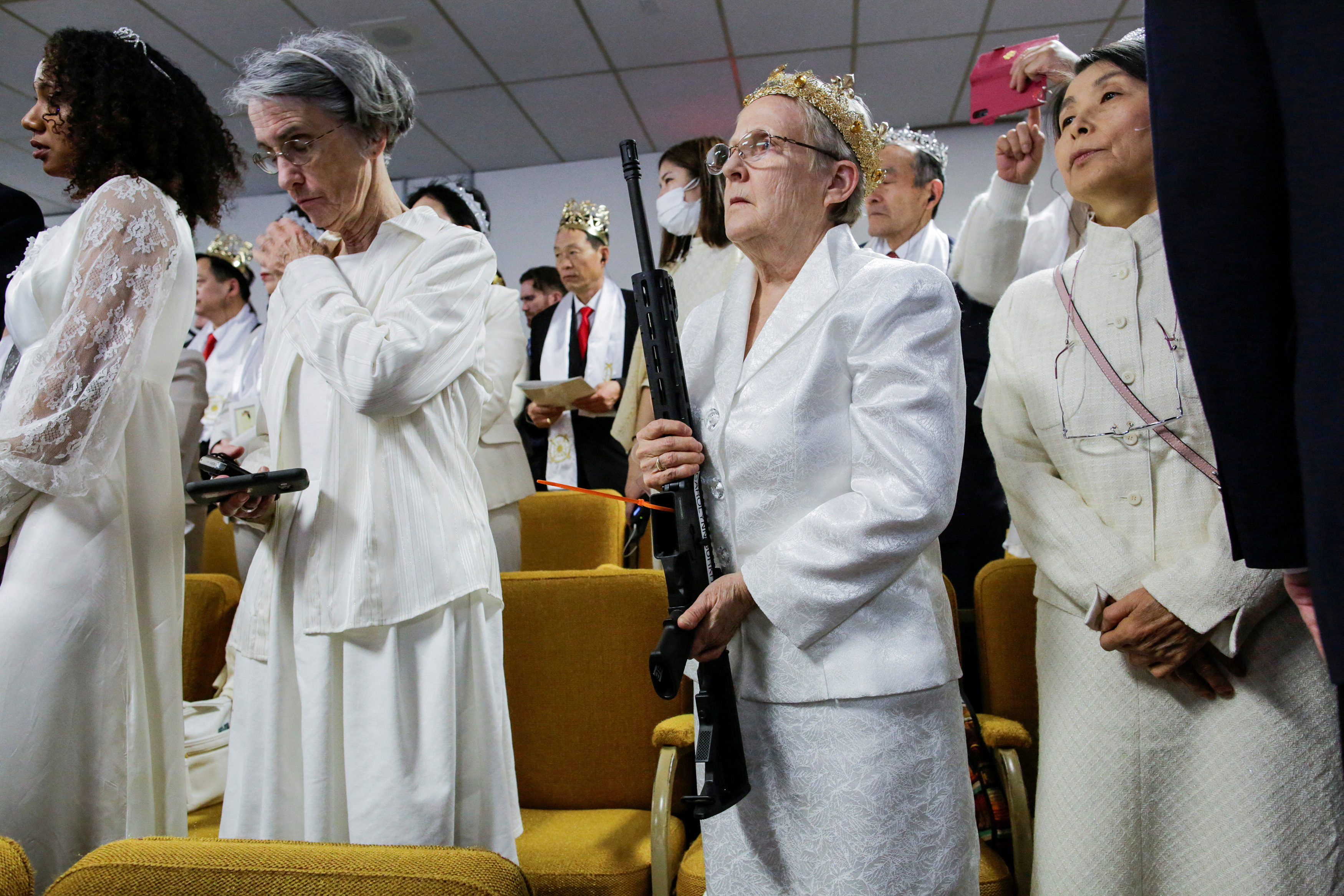FILE PHOTO: A woman holds her AR-15-style rifle as people attend a blessing ceremony with their AR-15-style rifles in their cases at the Sanctuary Church in Newfoundland