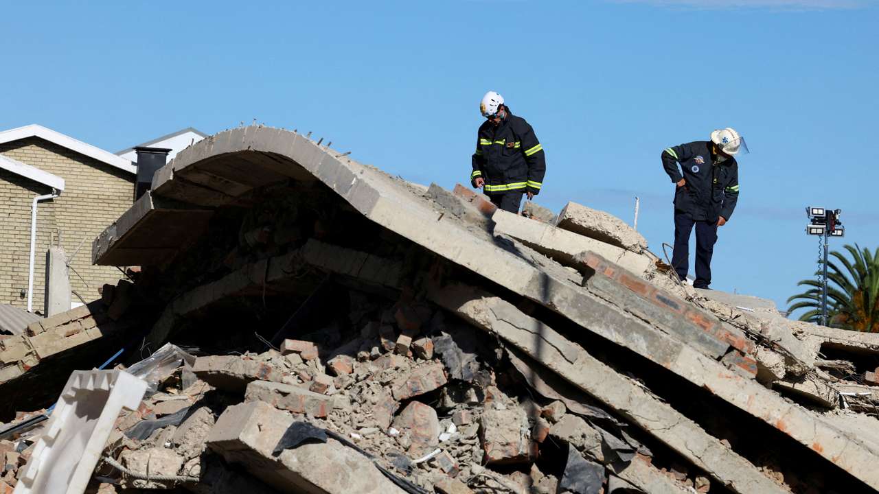 FILE PHOTO: Rescuers work to rescue construction workers trapped under a building that collapsed in George