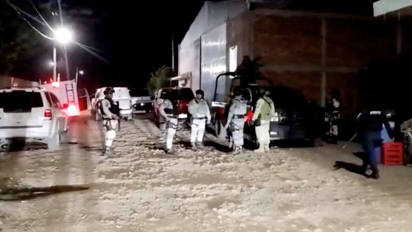 Security personnel work at the site where a group of armed attackers killed several people at a soccer sports field after a match in Salamanca