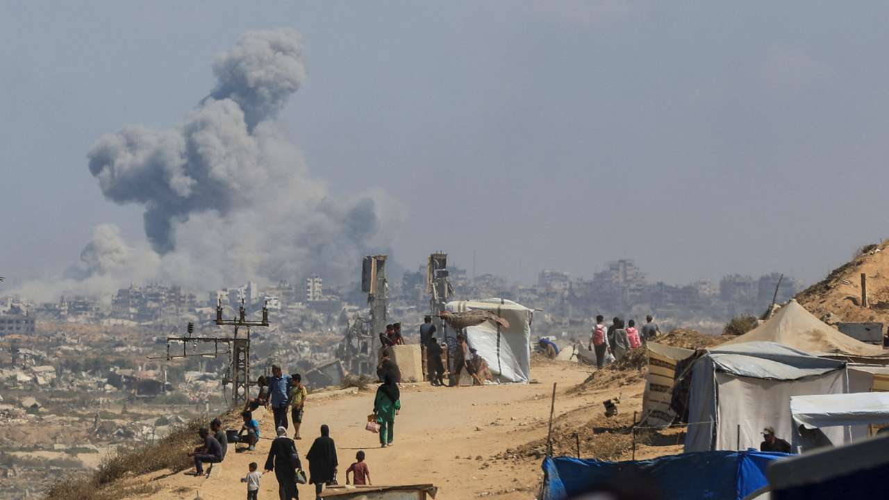 Smoke rises from an Israeli strike in the central Gaza Strip as displaced Palestinians flee northern Gaza