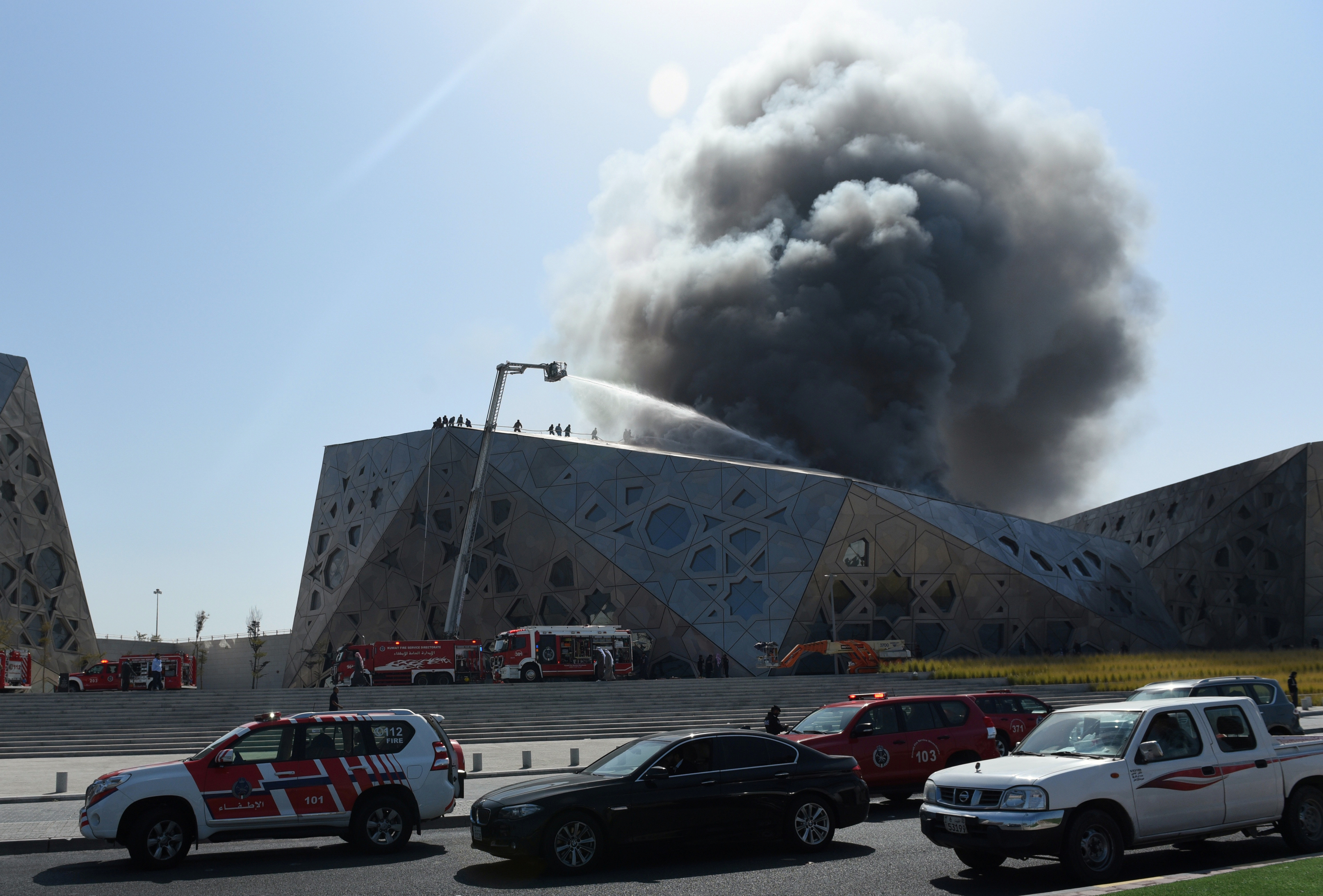Firefighters work to contain a large fire at Jaber Al Ahmad Cultural Centre in Kuwait City