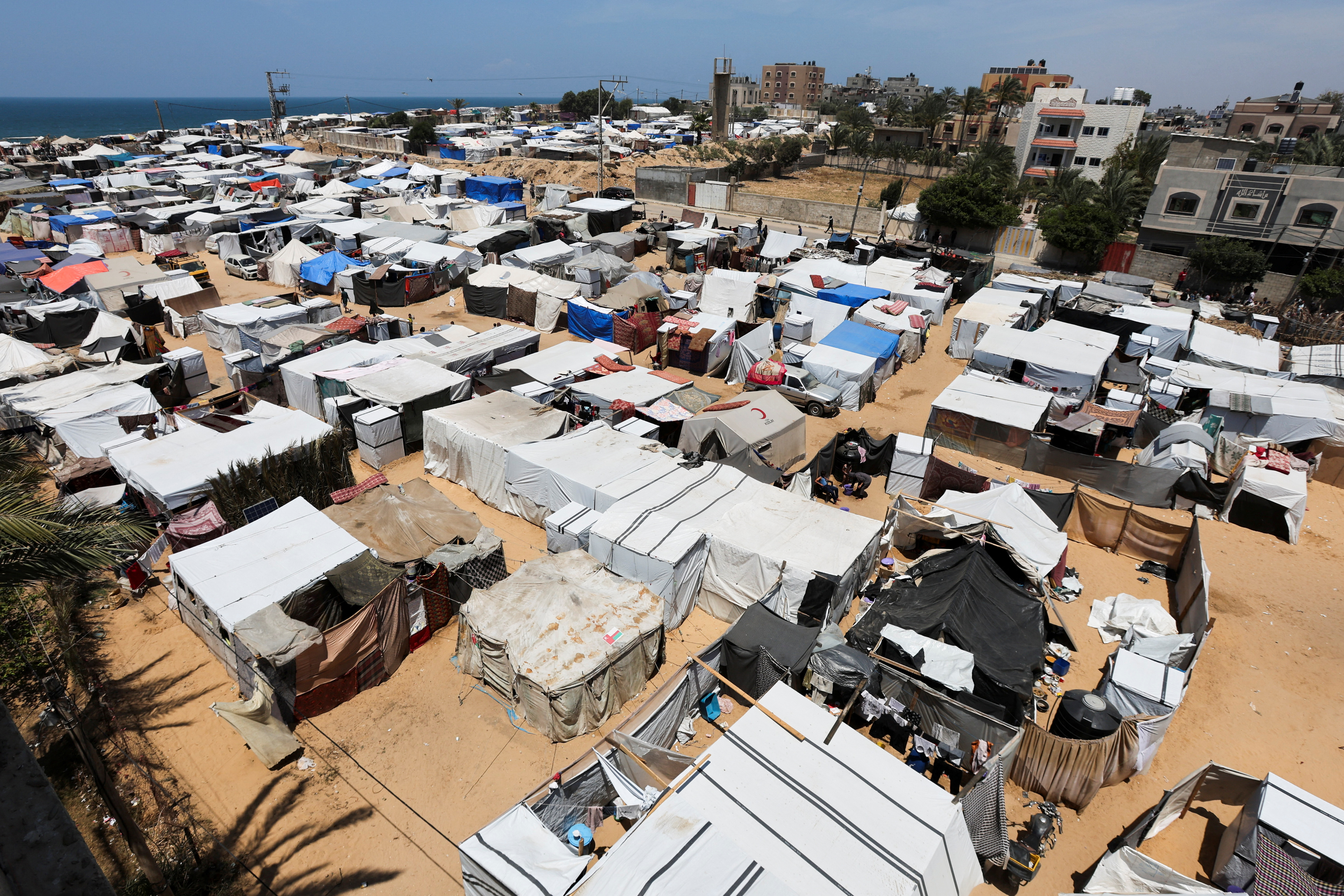 Displaced Palestinians, who fled their house due to Israeli strikes, shelter at a tent camp, amid the ongoing conflict between Israel and the Palestinian Islamist group Hamas, in Deir Al-Balah in central Gaza Strip