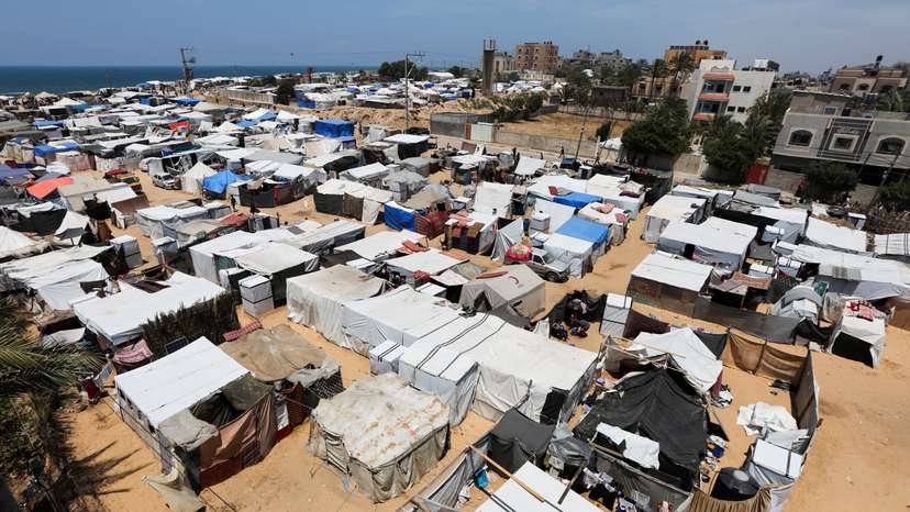 Displaced Palestinians, who fled their house due to Israeli strikes, shelter at a tent camp, amid the ongoing conflict between Israel and the Palestinian Islamist group Hamas, in Deir Al-Balah in central Gaza Strip