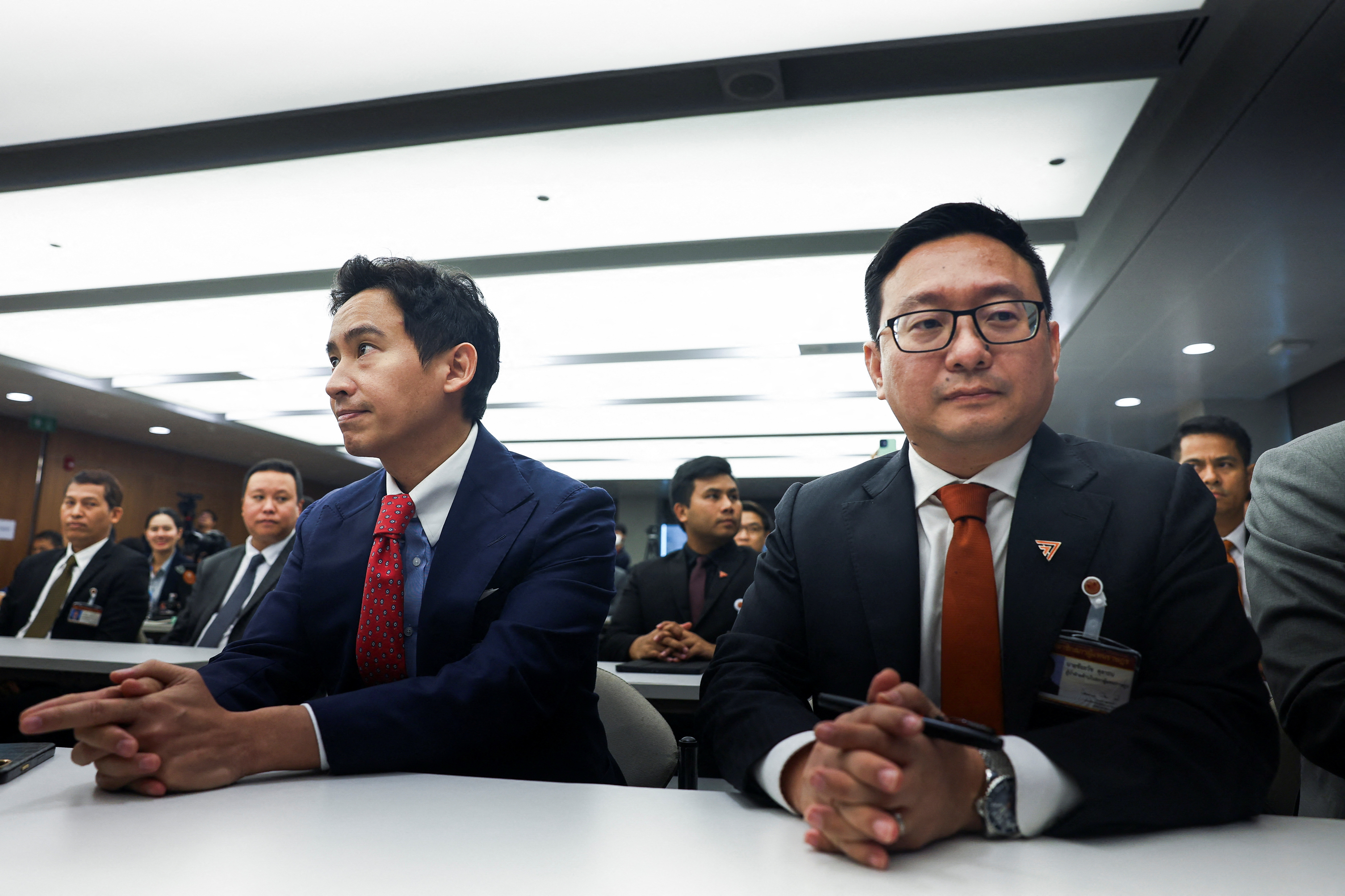 Former Move Forward Party leader Pita Limjaroenrat and party's members sit on the day Thailand's Constitutional Court delivers its verdict on election winner's bid to amend a law against insulting the monarchy, in Bangkok