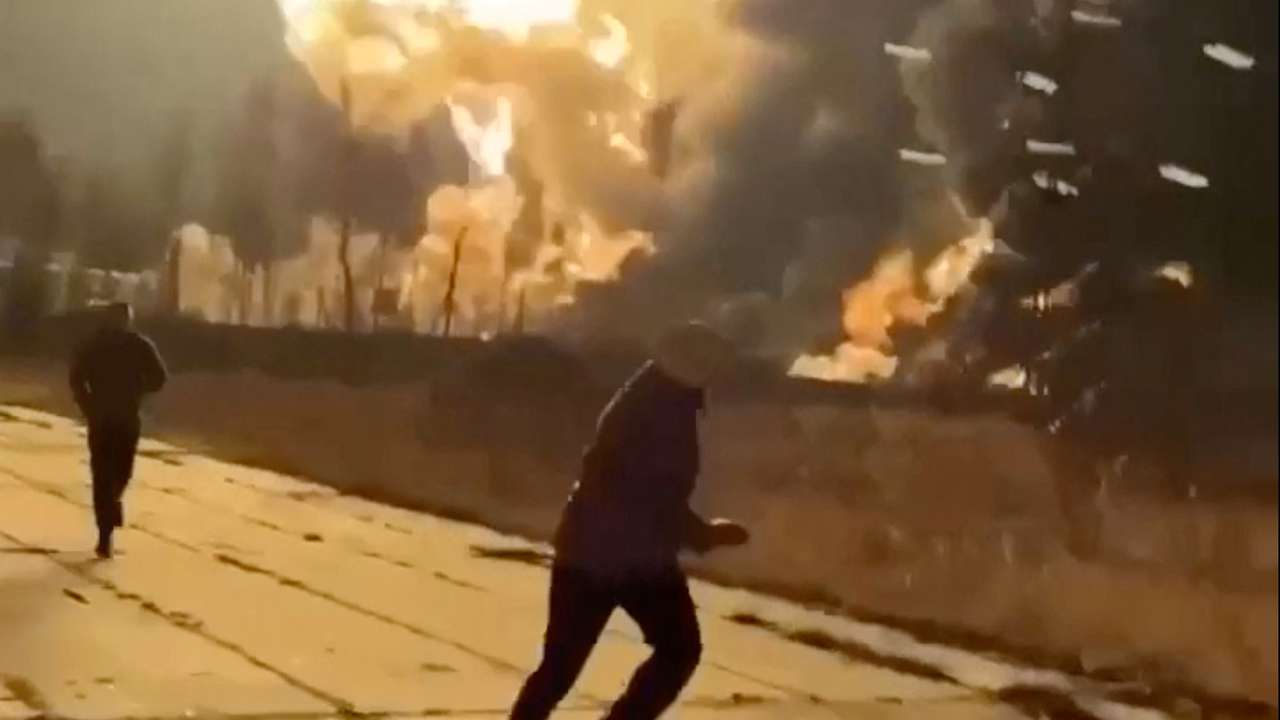 People run as smoke rises from an explosion during what the governor of Russia's Ryazan region southeast of Moscow describes as an air attack, in Ryazan