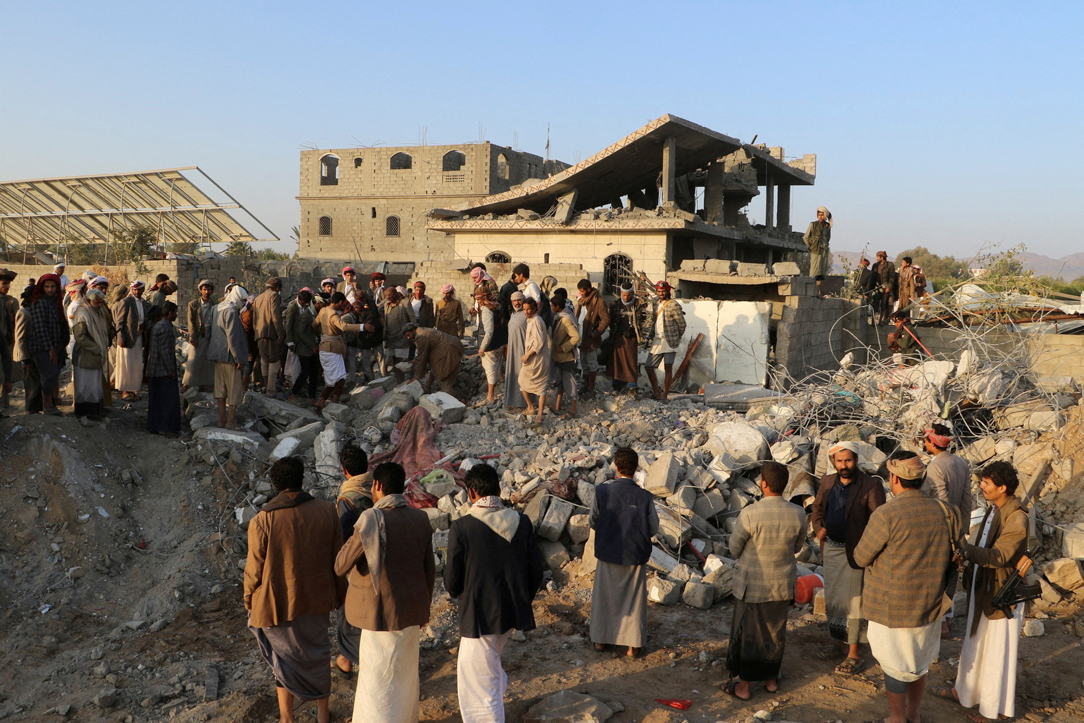 People gather at the site of a house hit by a U.S. strike in Saada