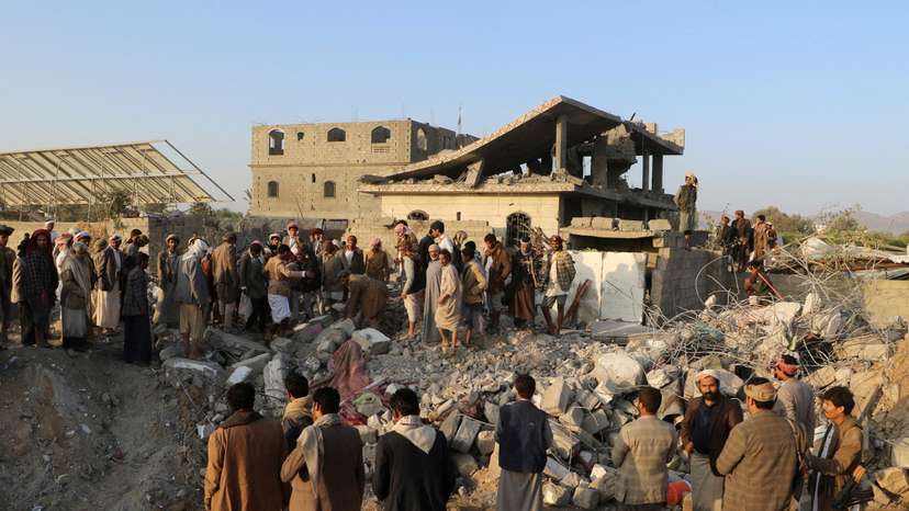 People gather at the site of a house hit by a U.S. strike in Saada