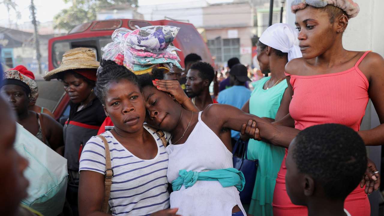 People react at a crime scene, in Port-au-Prince