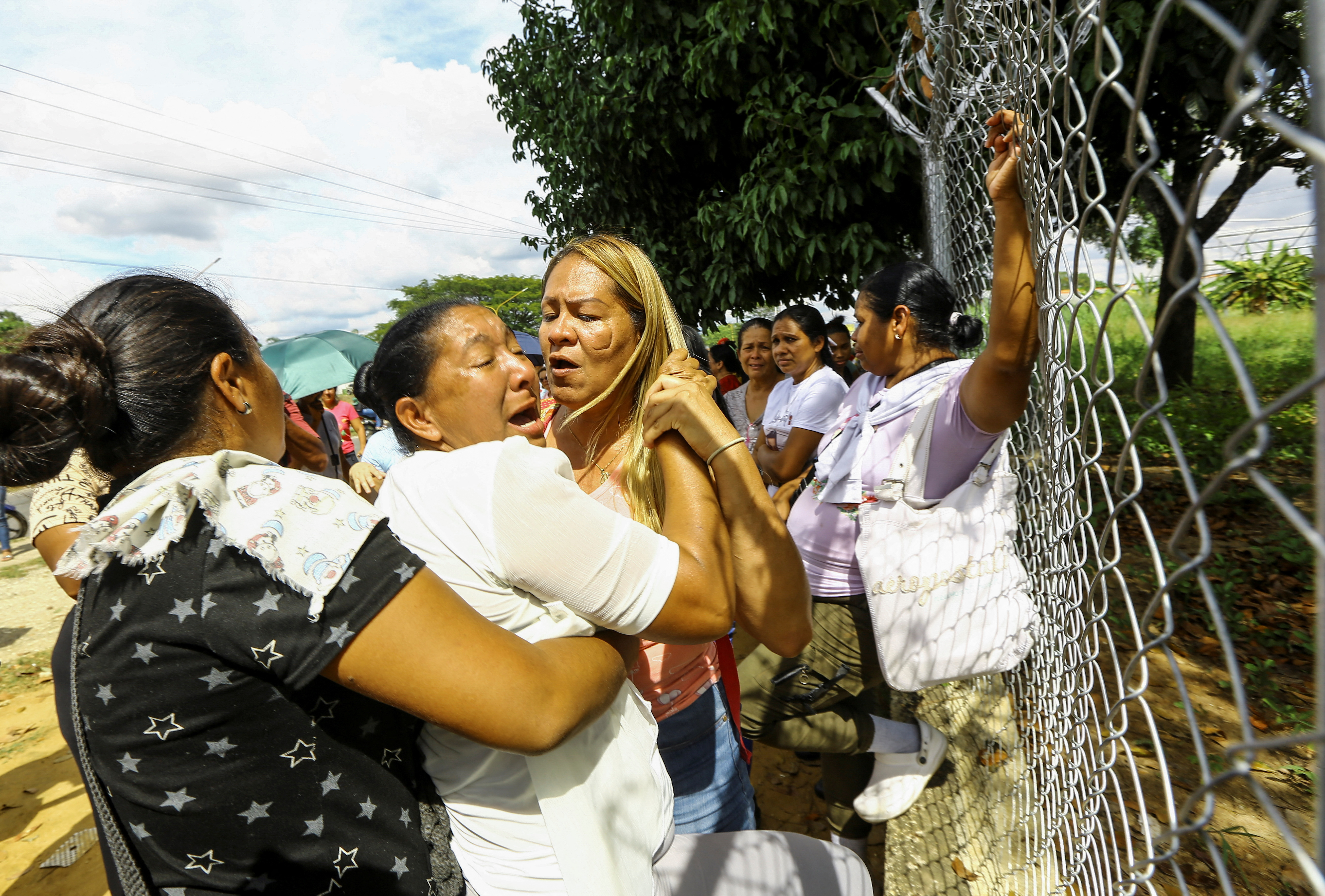 People wait outside the prison for the release of their loved ones detained during protests, in Tocuyito