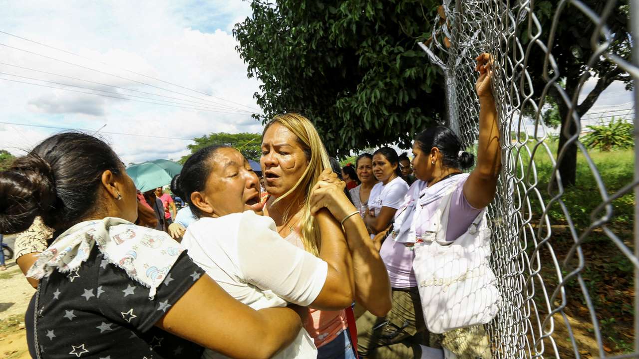 People wait outside the prison for the release of their loved ones detained during protests, in Tocuyito