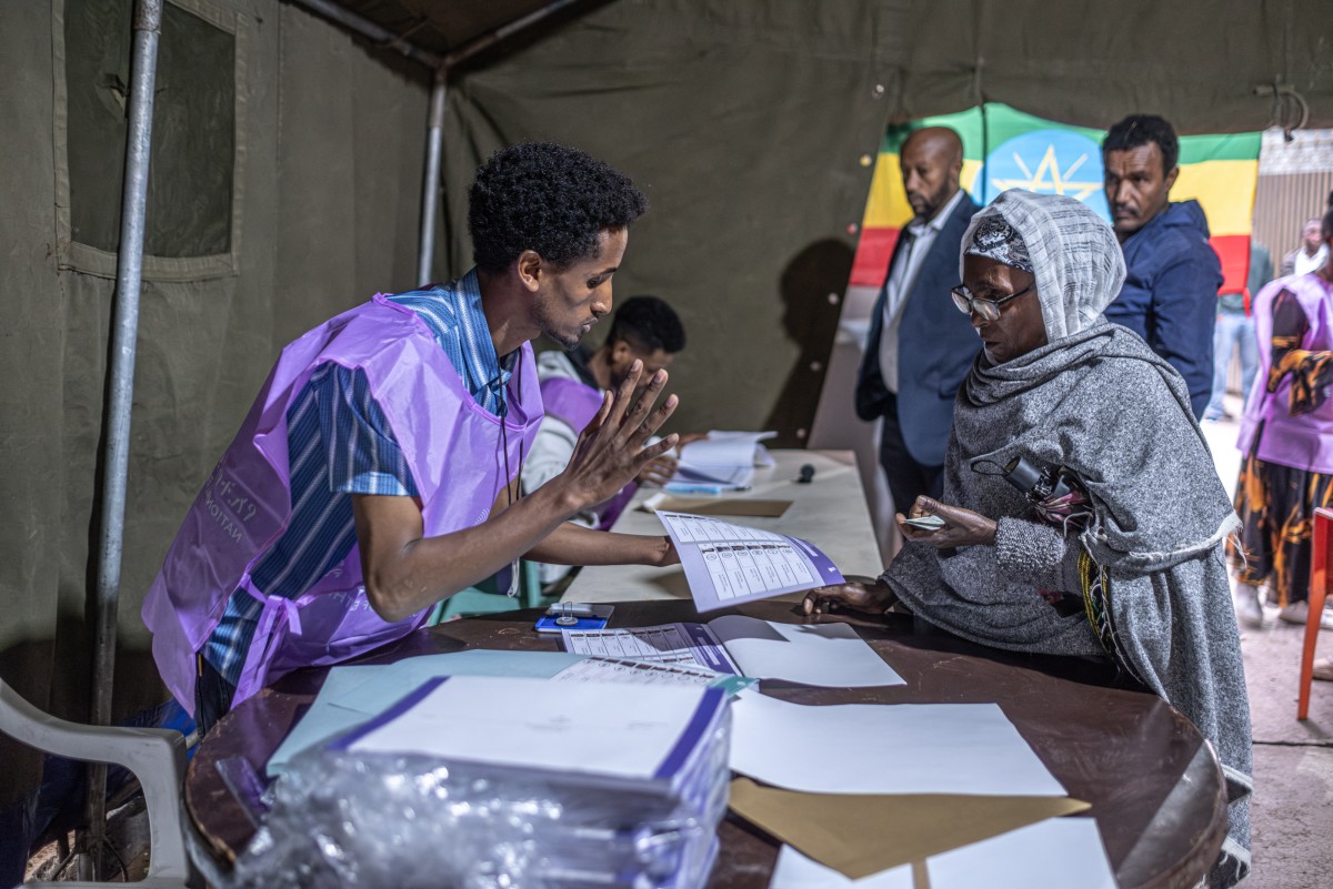 A National Election Board of Ethiopia (NEBE) official explains voting procedures to a voter at Shalla Park polling station in Addis Ababa, on June 1, 2026, during the 2026 Ethiopian parliamentary elections. Ethiopians began voting on June 1, 2026 in parliamentary elections, with the party of outgoing Prime Minister Abiy Ahmed, who is running for another term, expected to win. 
Around 50 million voters are eligible to vote in the election for members of parliament, who will in turn select the prime minister. (Photo by Marco Simoncelli / AFP)