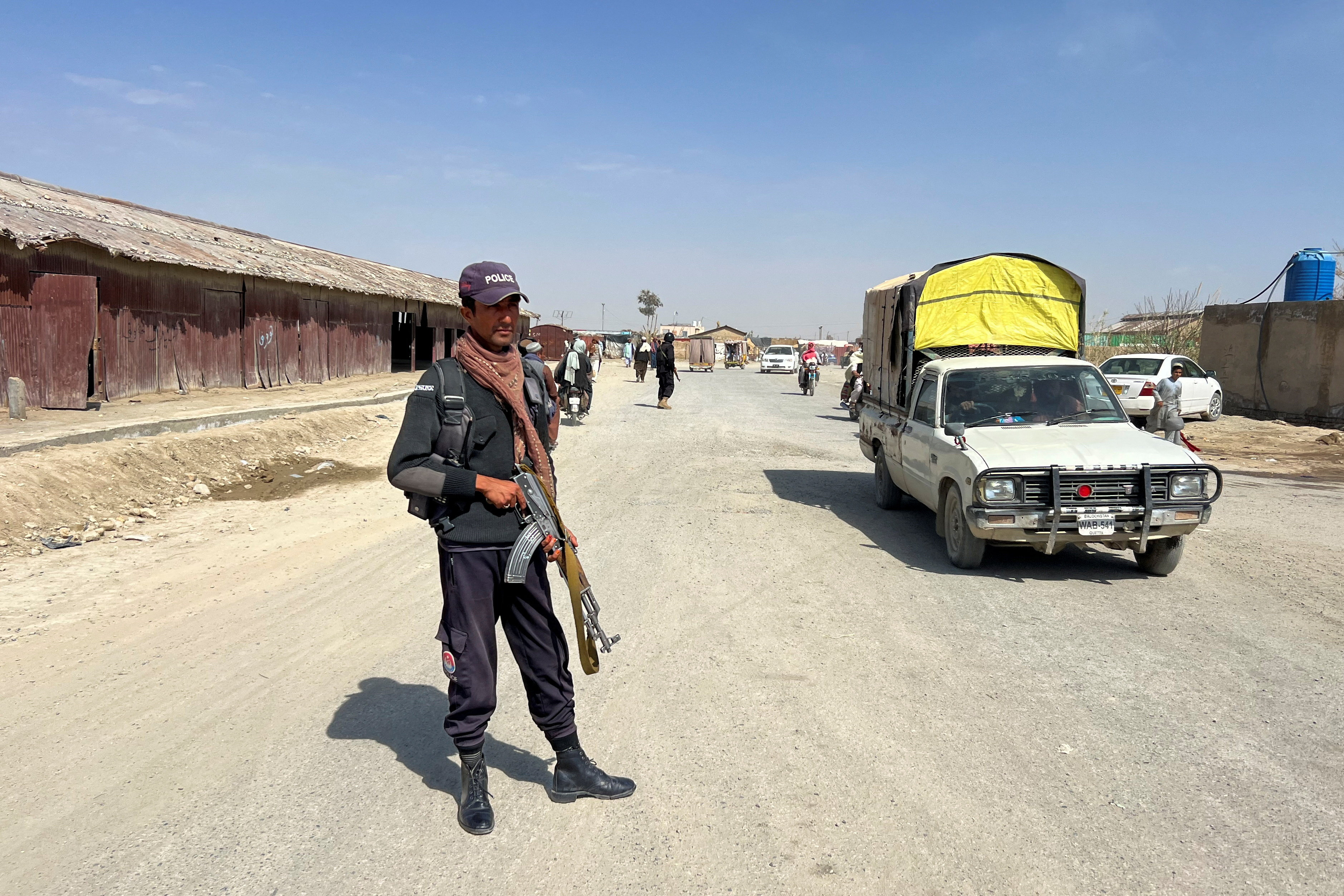 A police officer stands guard along a road leading to the border crossing along the Pakistan-Afghanistan in Balochistan Province, in Chaman