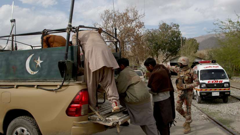 Plain clothes security force perosnnel, who were rescued from a train after it was attacked by separatist militants, arrive at a railway station in Mach
