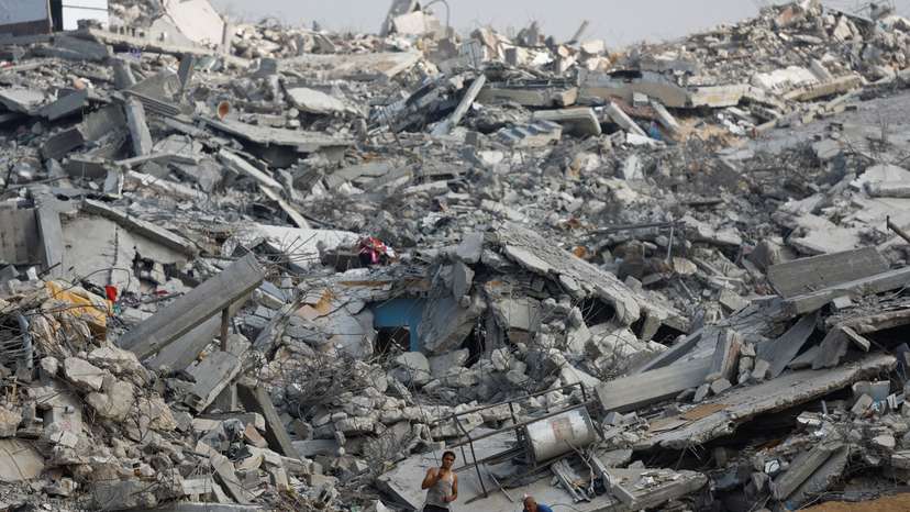 Palestinians work amid the rubble of destroyed buildings, during a ceasefire between Israel and Hamas, in Jabalia